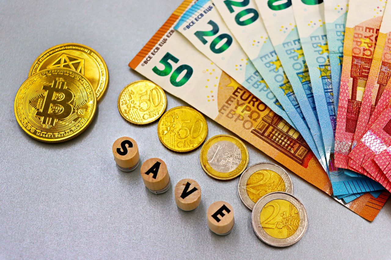 Euro banknotes and Bitcoin coins arranged with save text for finance concept.